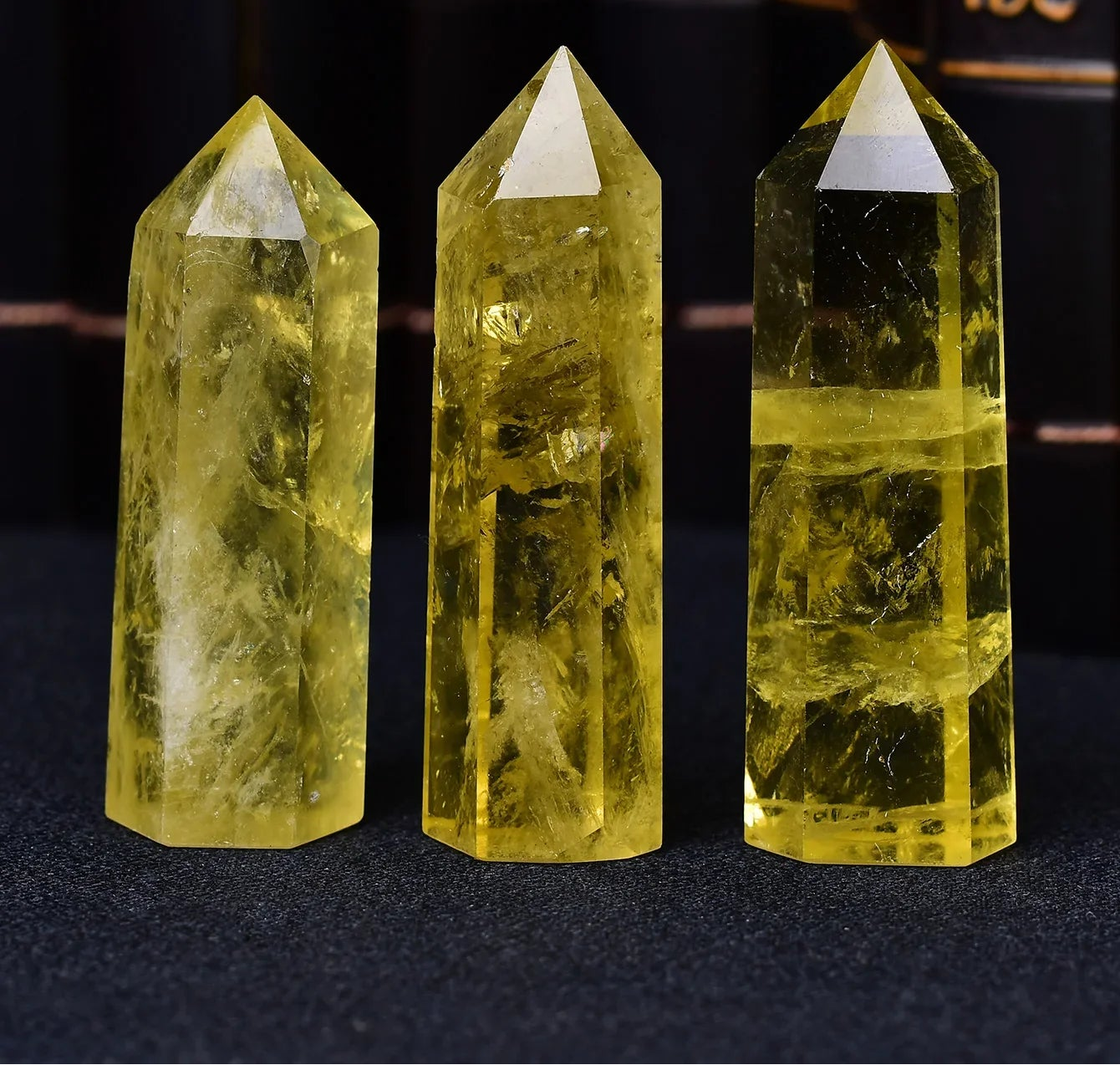 Three yellow crystal points on a dark background with blurred text in the background
