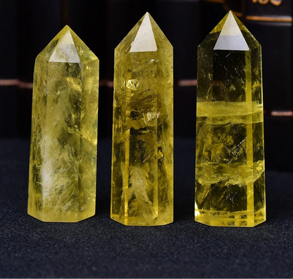 Three yellow crystal points on a dark background with blurred text in the background