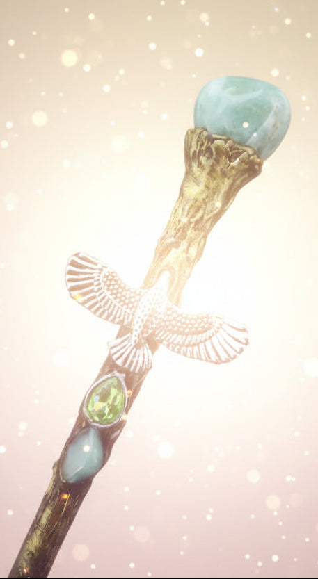 Decorative hair stick with owl charm and green gemstones on a dark background