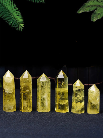 Set of yellow crystal points on a dark background with green leaves.
