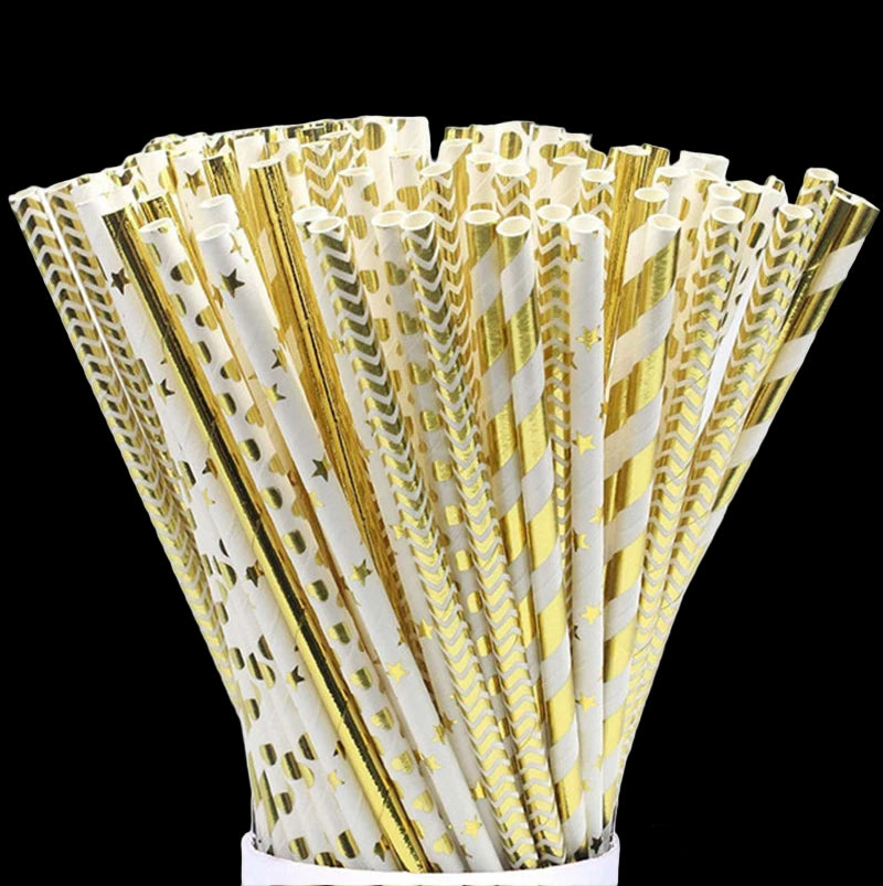 Assorted gold and white paper straws in a cup on a white background