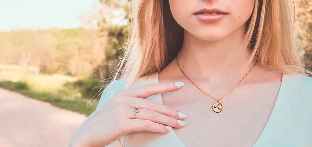 Woman wearing a light-colored blouse with a blurred outdoor background