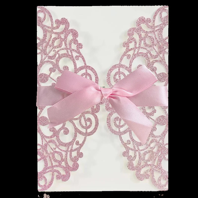 Decorative card with pink glittery lace design and a pink bow on a white background.