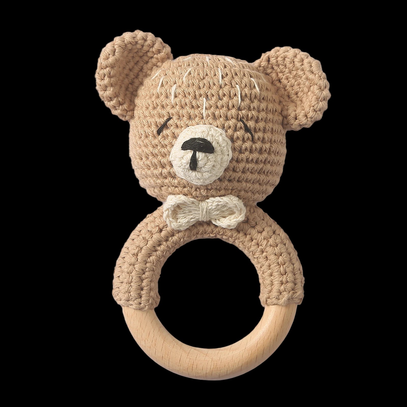 Crocheted teddy bear rattle with wooden ring on a white background