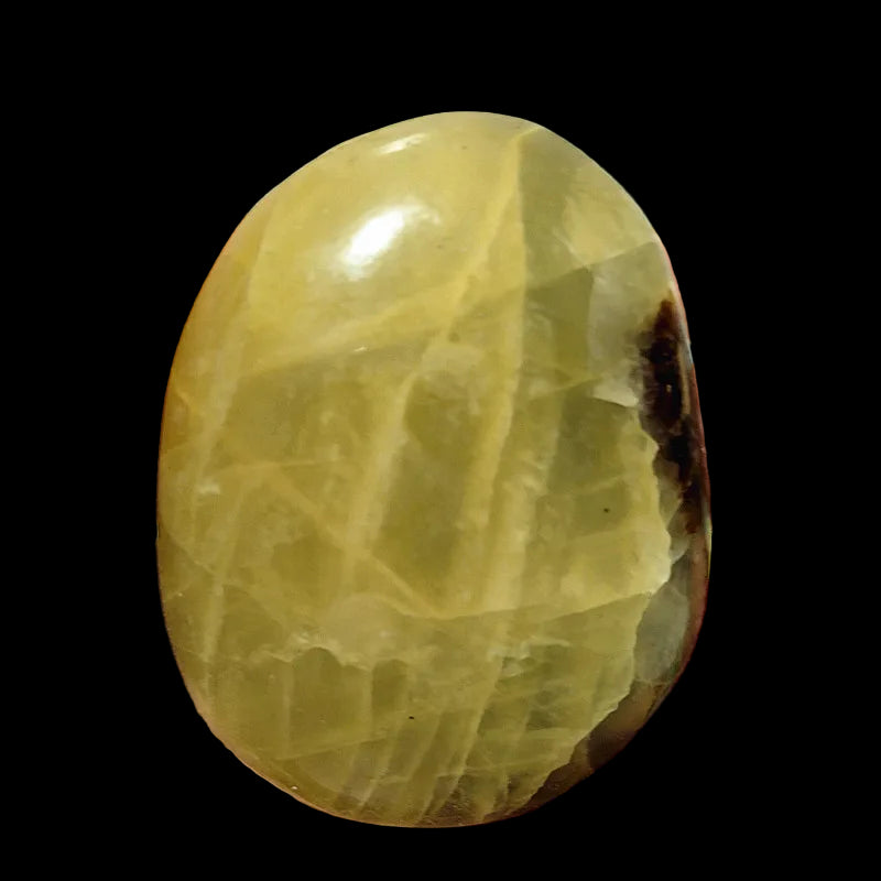 Oval-shaped green stone held in a hand against a white background