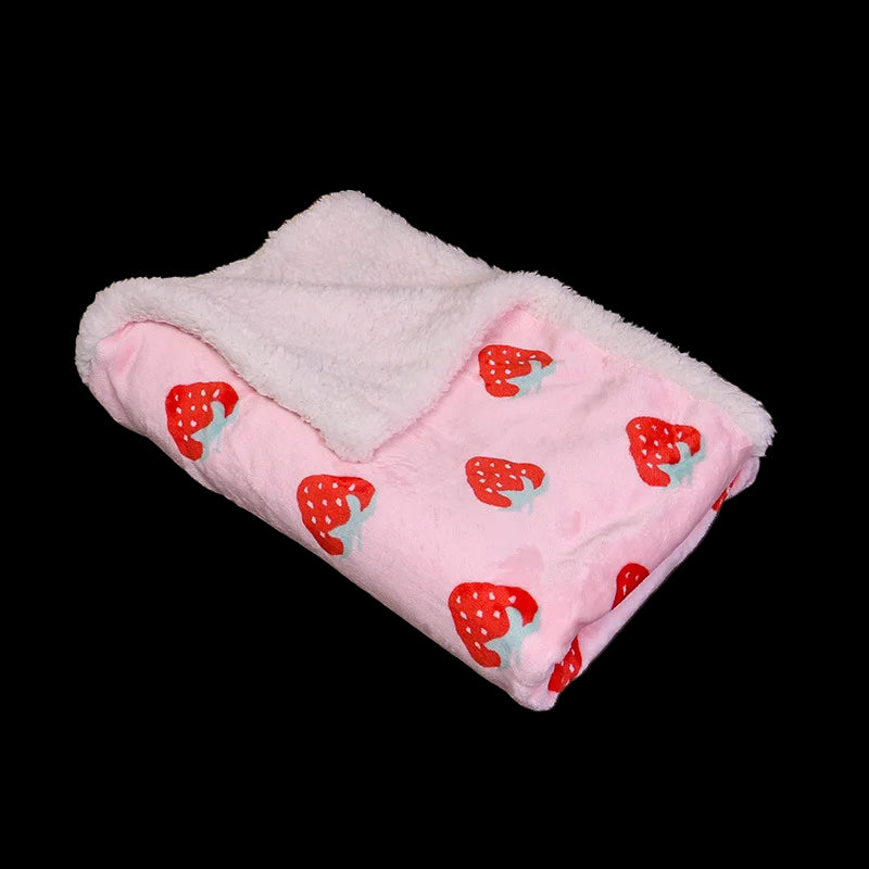 Pink blanket with strawberry pattern on a brown couch