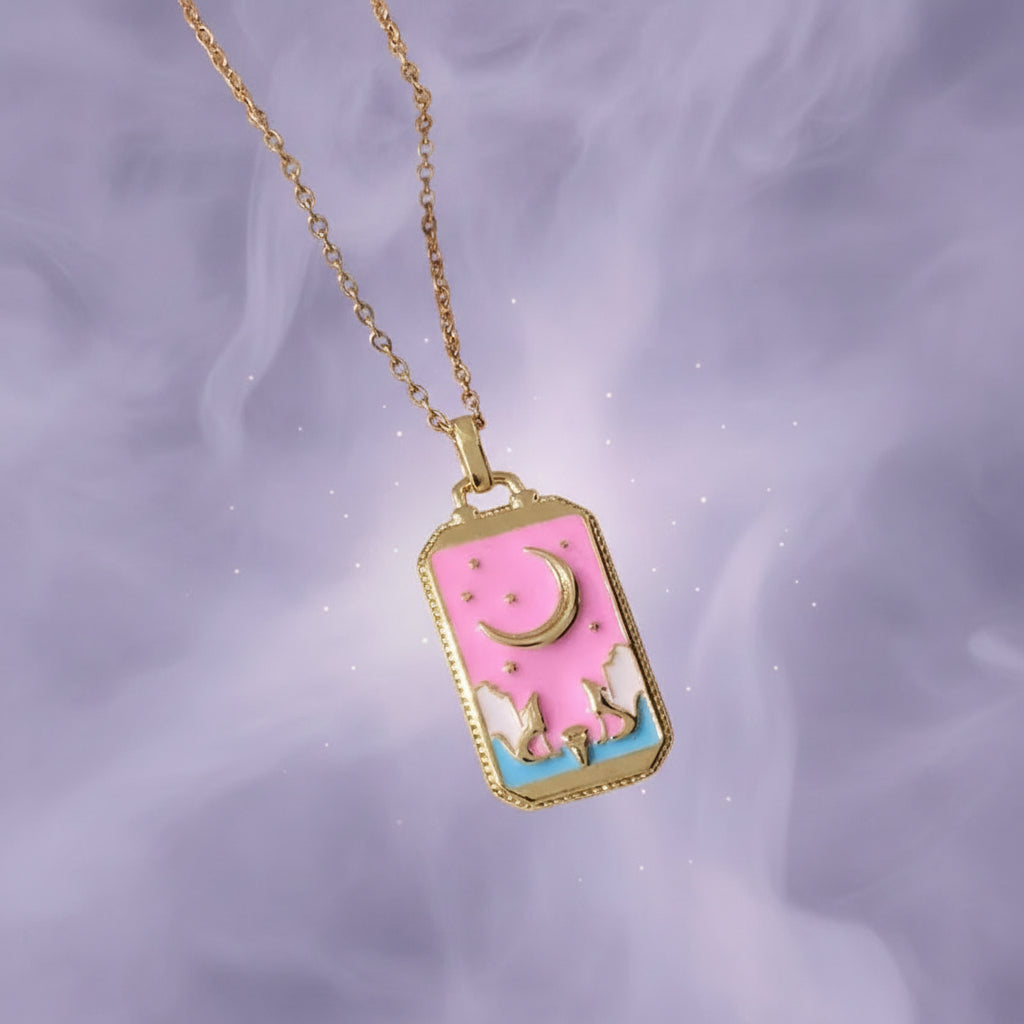 Necklace with a pink pendant featuring a unicorn and moon on a textured surface