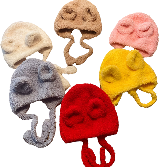 Set of colorful knitted hats with animal ears on a wooden surface
