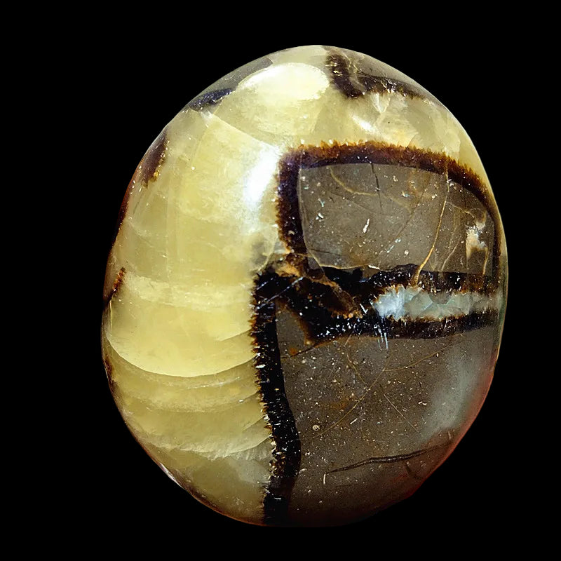 Hand holding a polished stone with layered colors