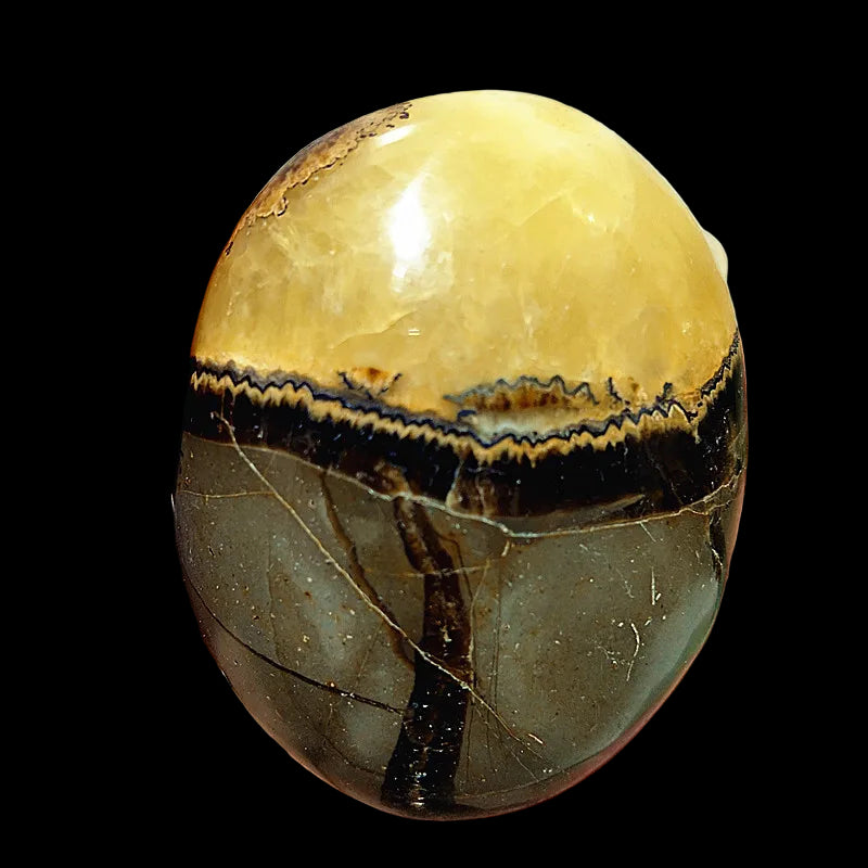 Hand holding a semi-precious stone with a striped pattern