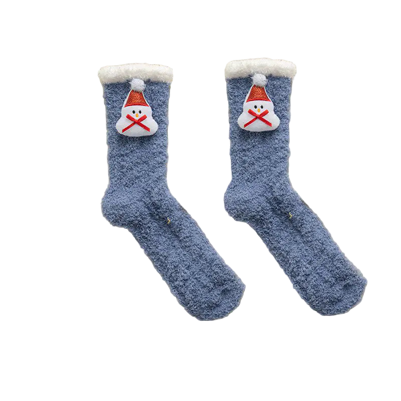 Pair of blue fuzzy socks with Santa face design on a white fluffy surface
