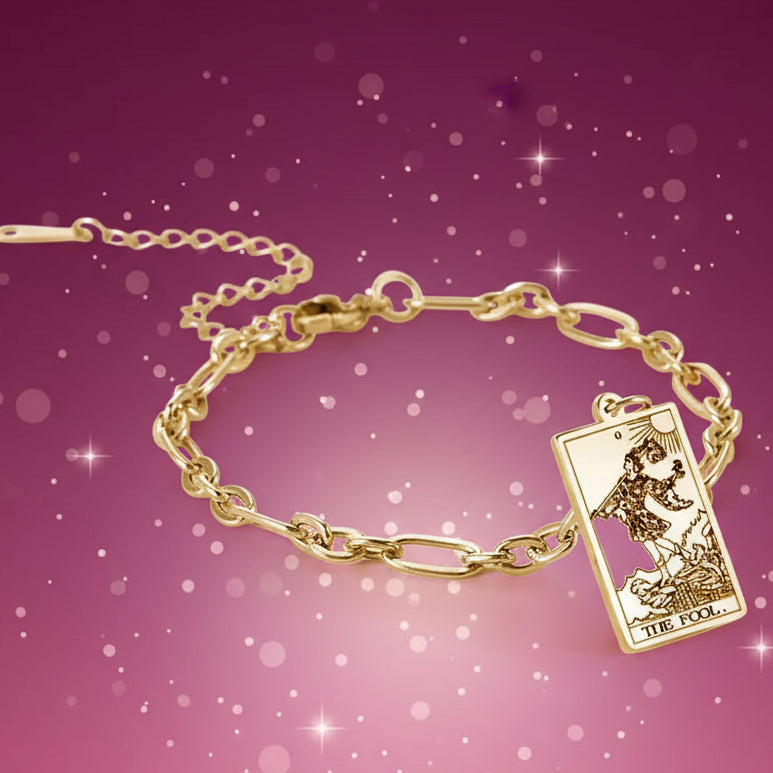 Gold bracelet with a tarot card charm on a white background
