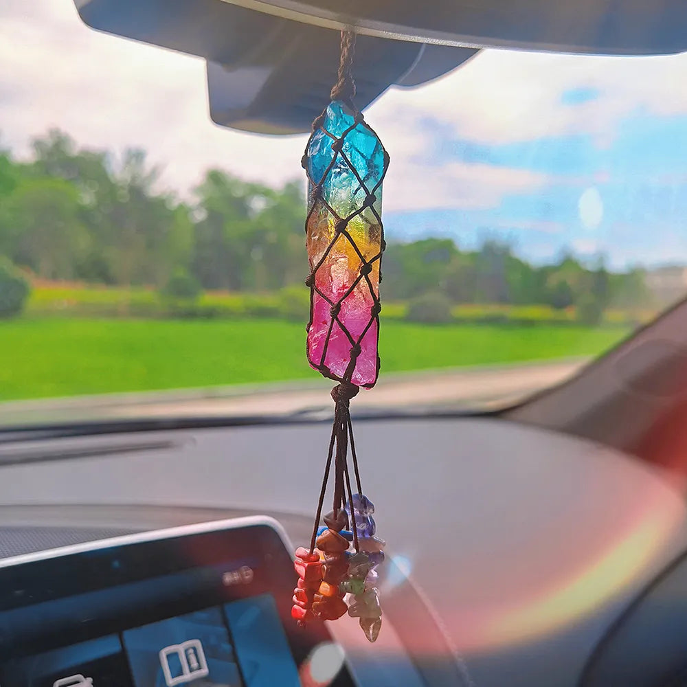 Colorful crystal car hanging inside a car with a blurred outdoor background