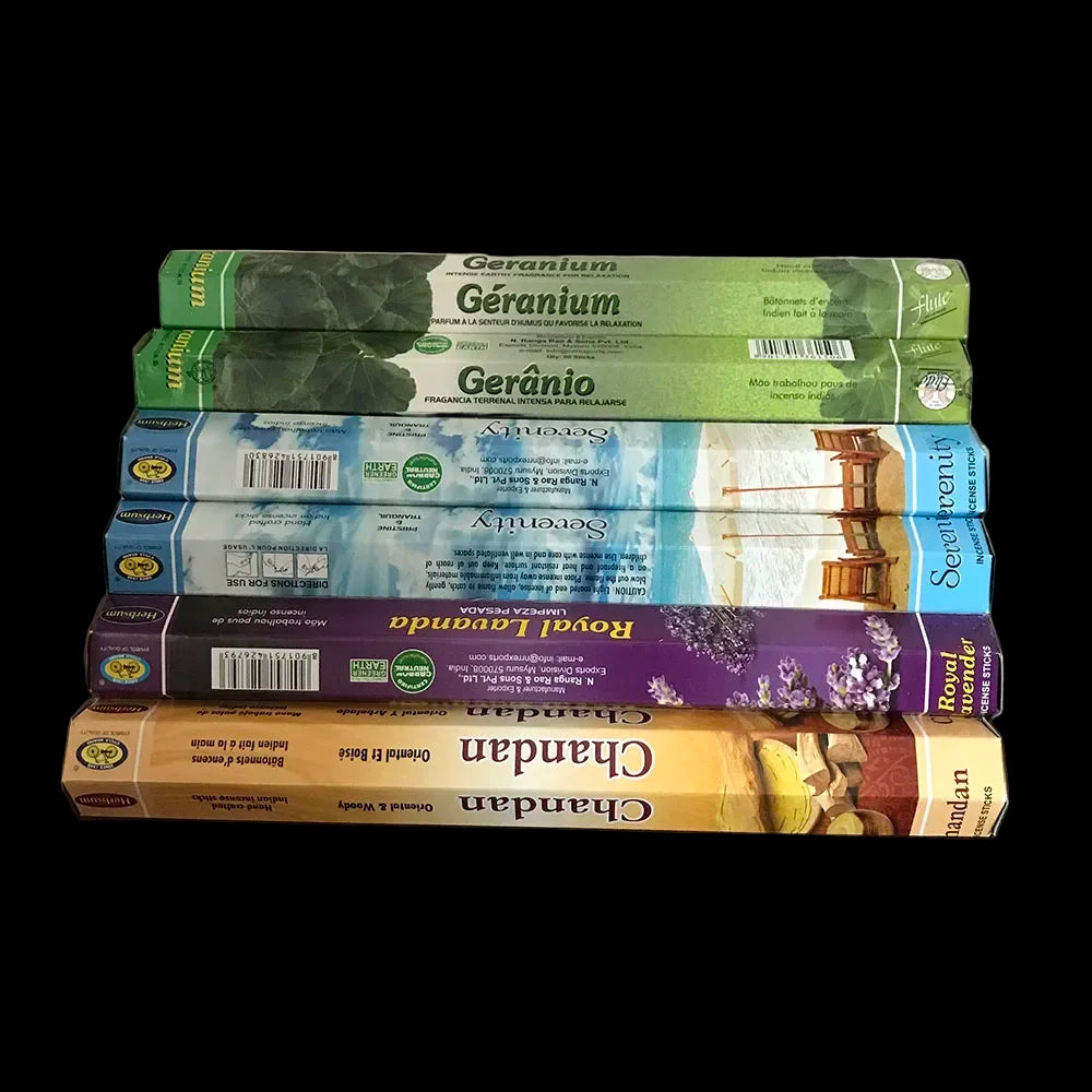 Stack of incense boxes with various scents on a wooden surface