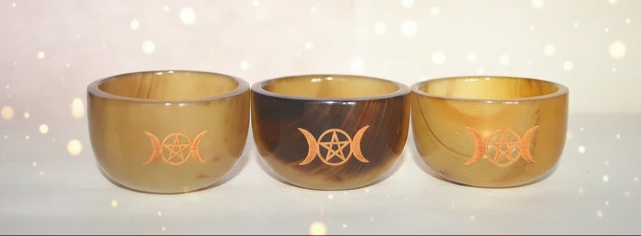 Three wooden bowls with engraved symbols on a white background