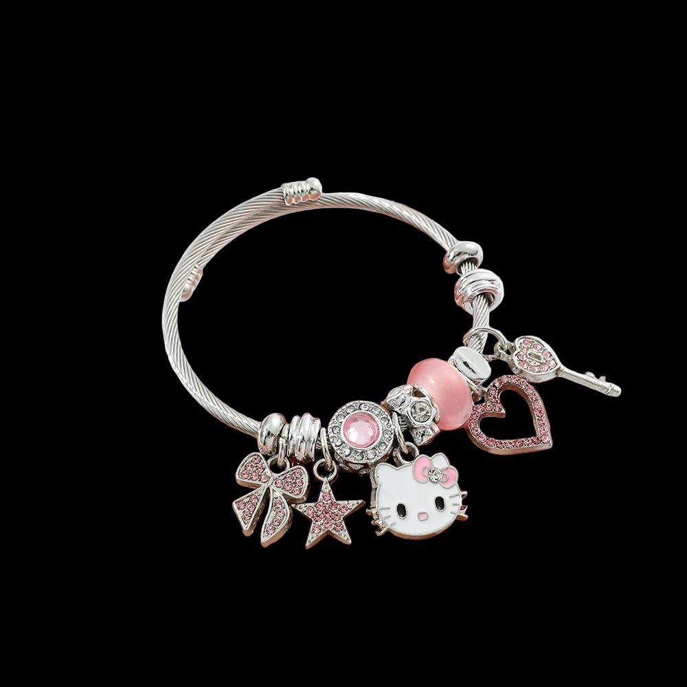 Hand holding a silver bracelet with various charms including a Hello Kitty character on a white background