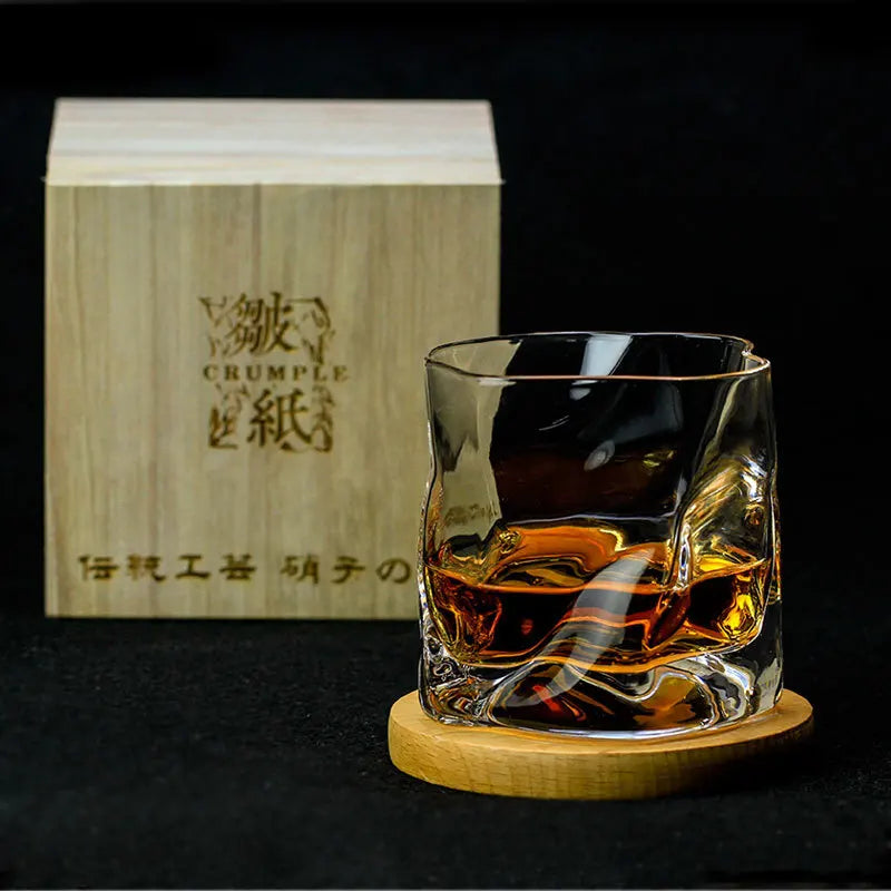 Glass of whiskey on a wooden coaster with a wooden box in the background