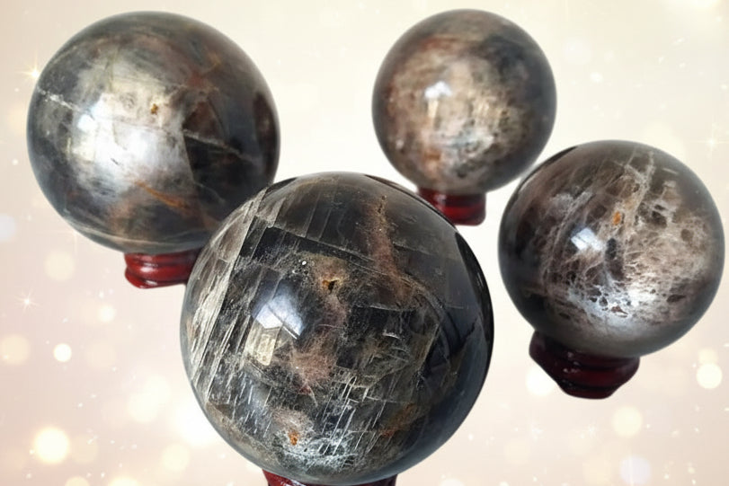 Four polished crystal spheres on a white background