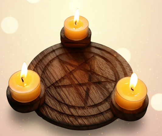 Wooden candle holder with three burning candles on a wooden surface