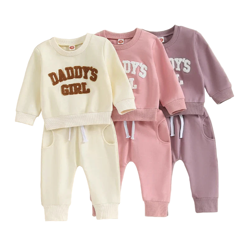 Three children's sweatshirt and pants sets with 'DADDY'S GIRL' text on a beige background.