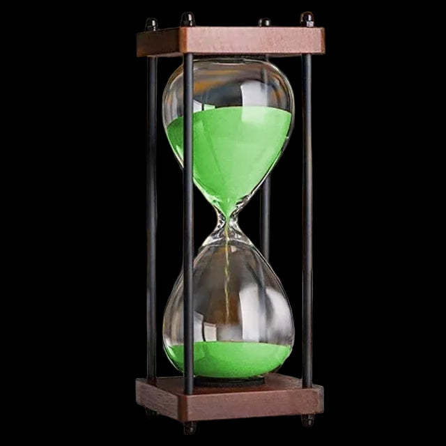 Sand timer with green sand on a blurred background