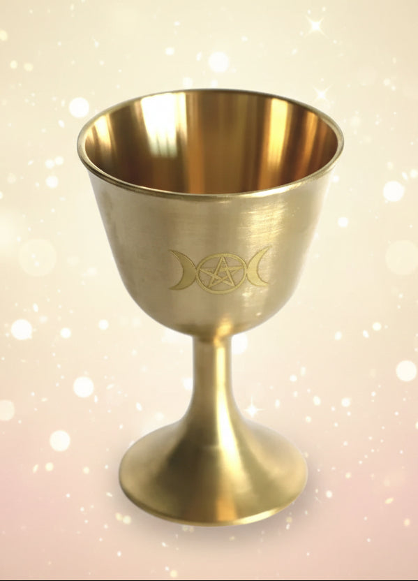 Gold goblet with engraved symbols on a white background