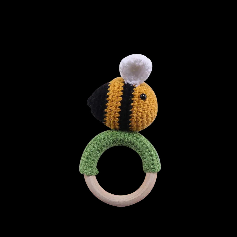 Crocheted bee-shaped rattle with a wooden ring on a white background