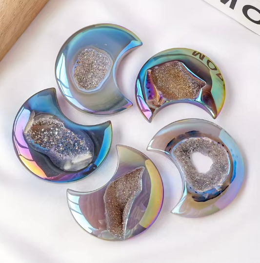 Five crescent-shaped iridescent resin coasters with glittery geode-like centers, arranged on a white surface.