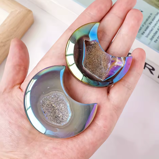 Hand holding a metallic, reflective object with a textured center.