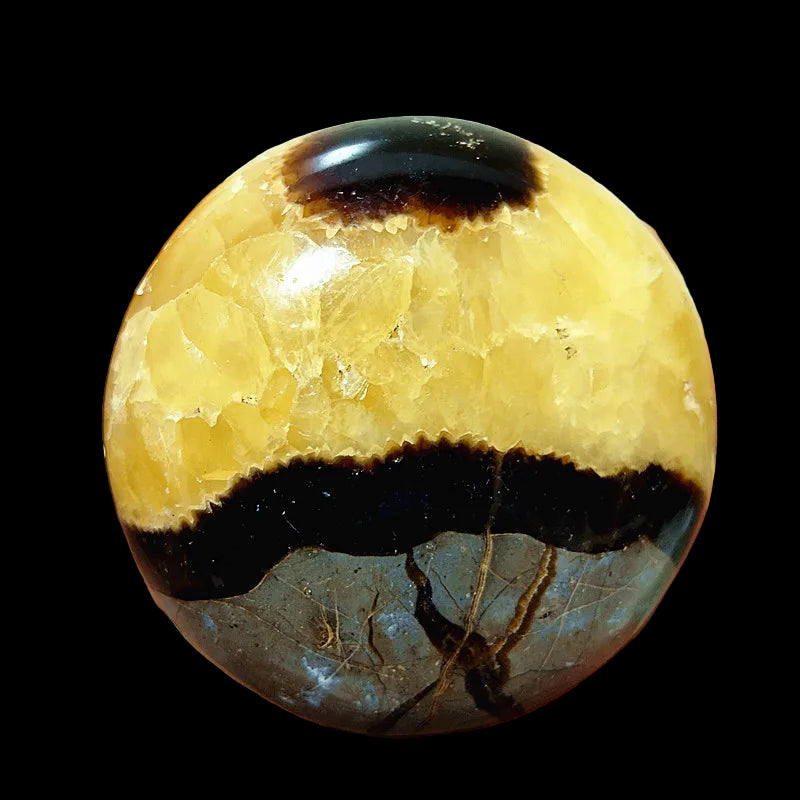 Hand holding a yellow and black marbled stone
