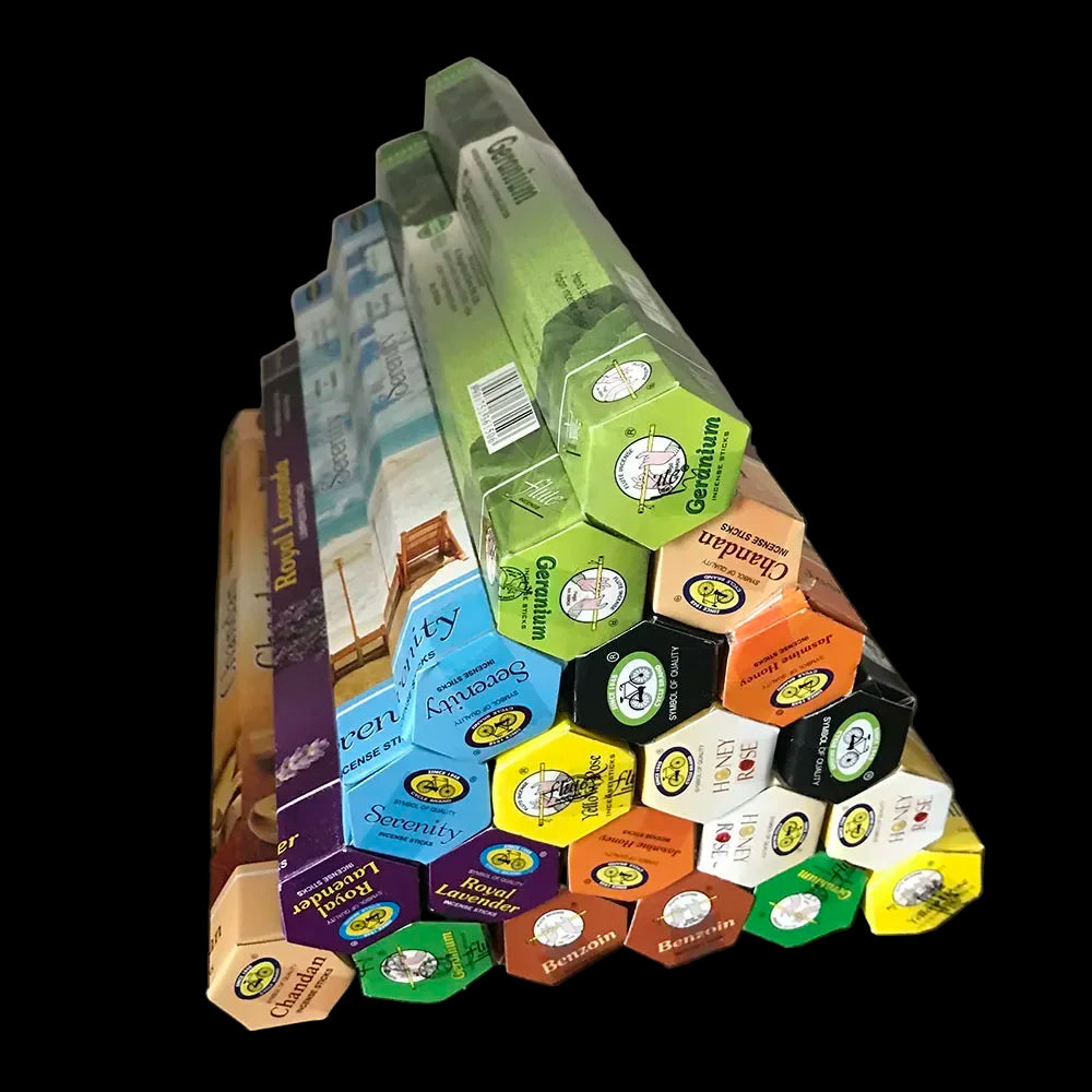 Stack of tea boxes arranged in a pyramid shape on a wooden surface.