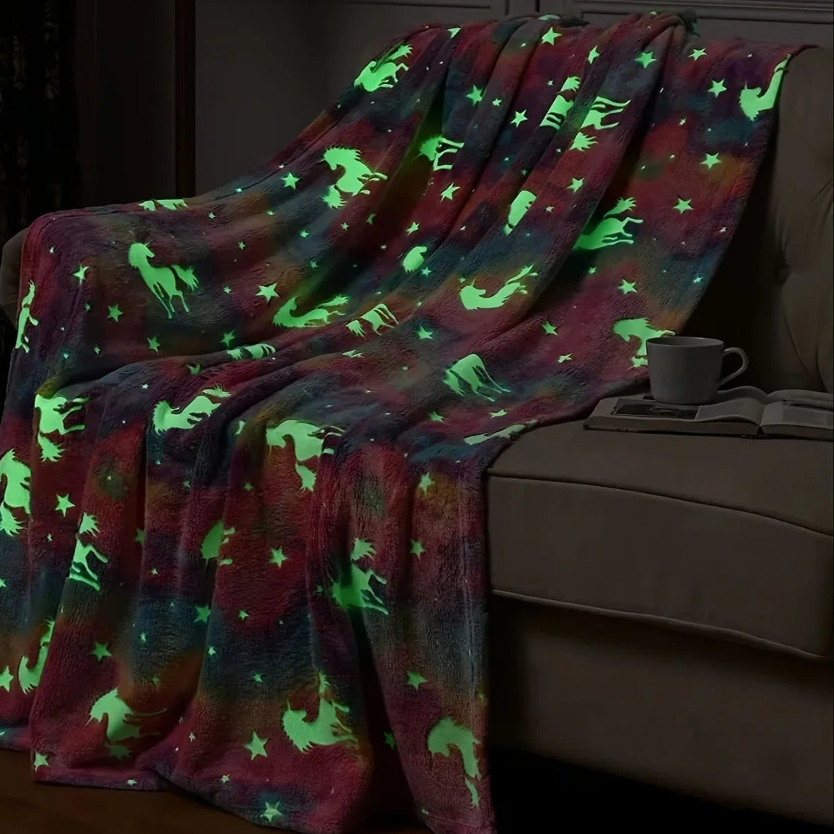 Glowing blanket with animal patterns draped over a couch in a dimly lit room.