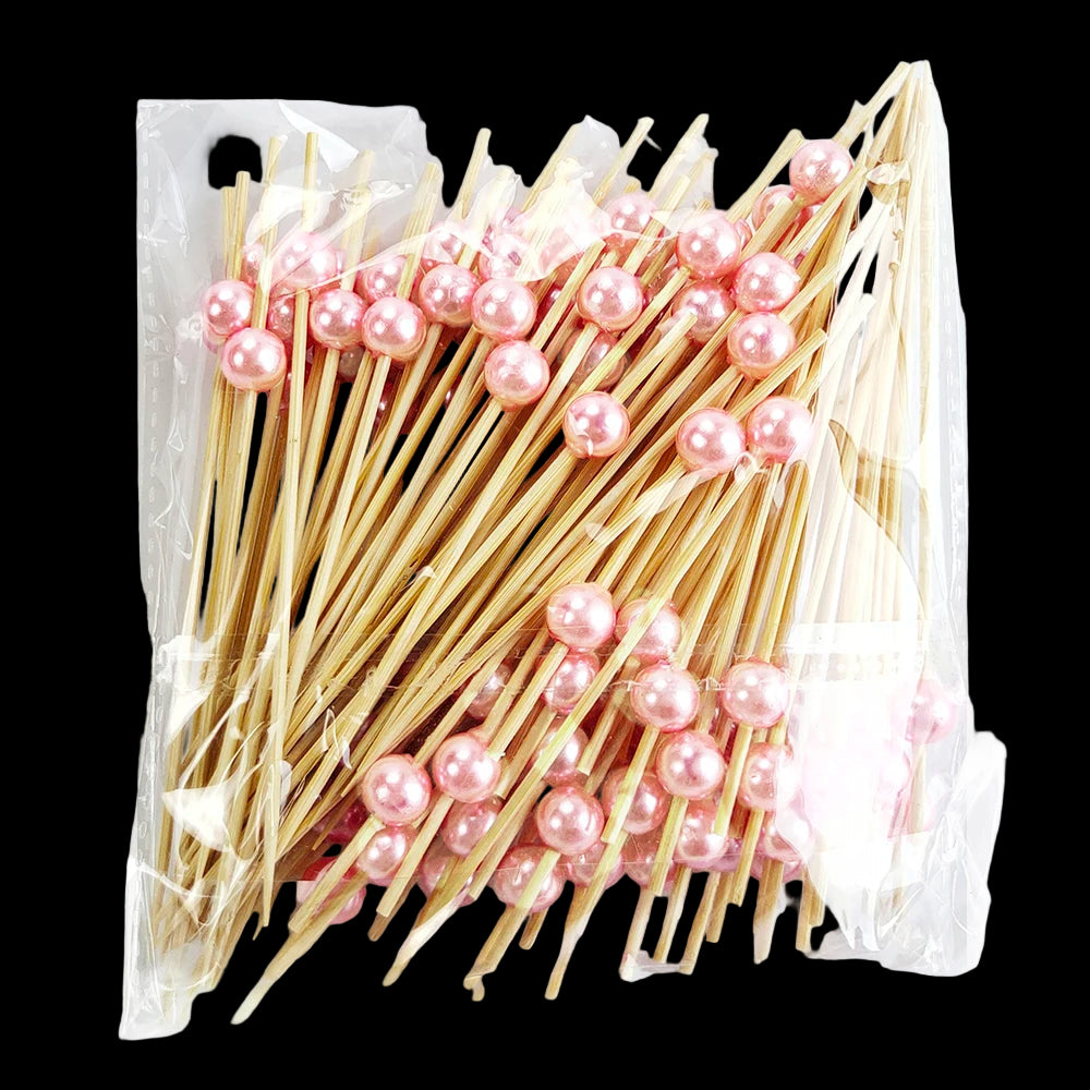 Packaged wooden skewers with pink pearls on a white background