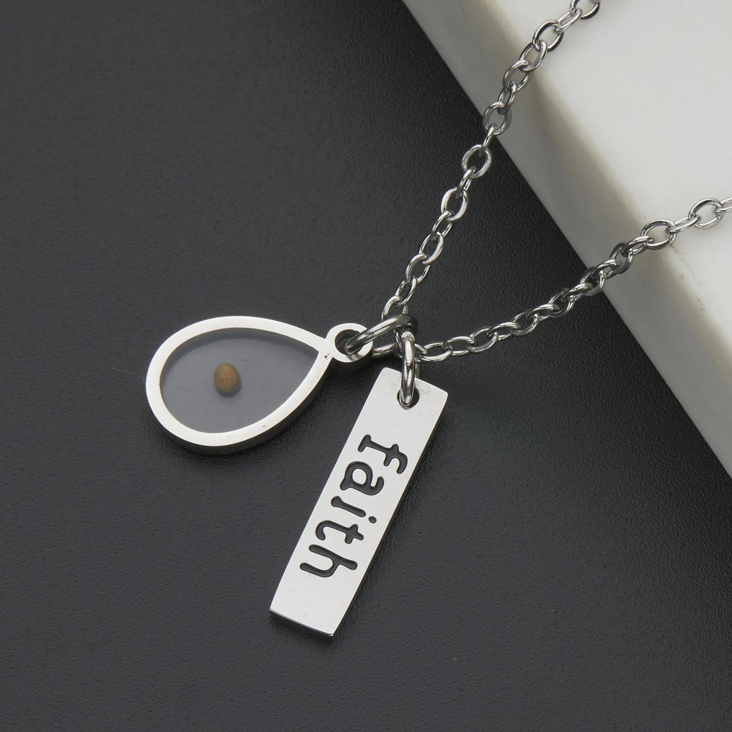 Necklace with 'faith' charm on a dark surface