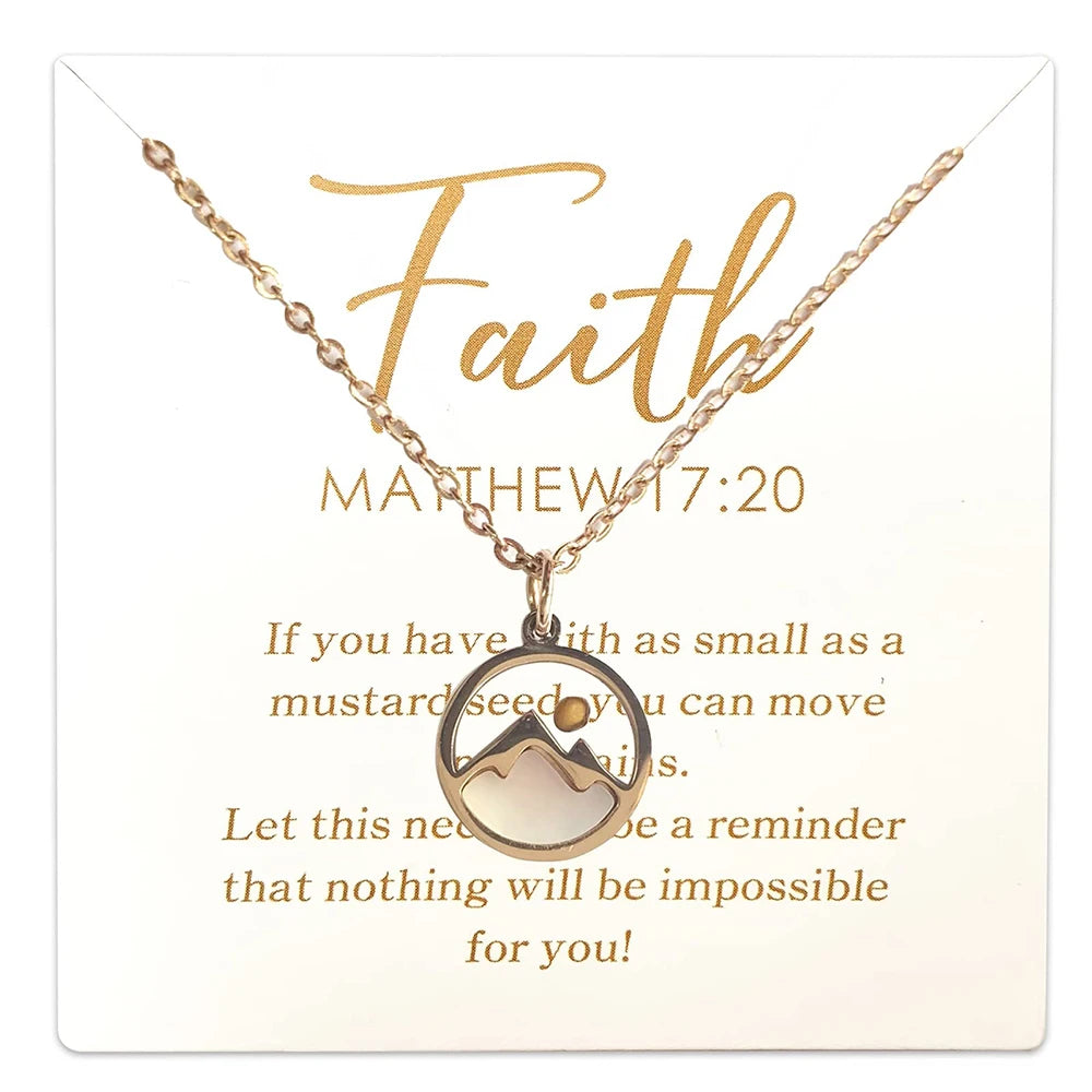 Gold necklace with mountain pendant on a card featuring inspirational text