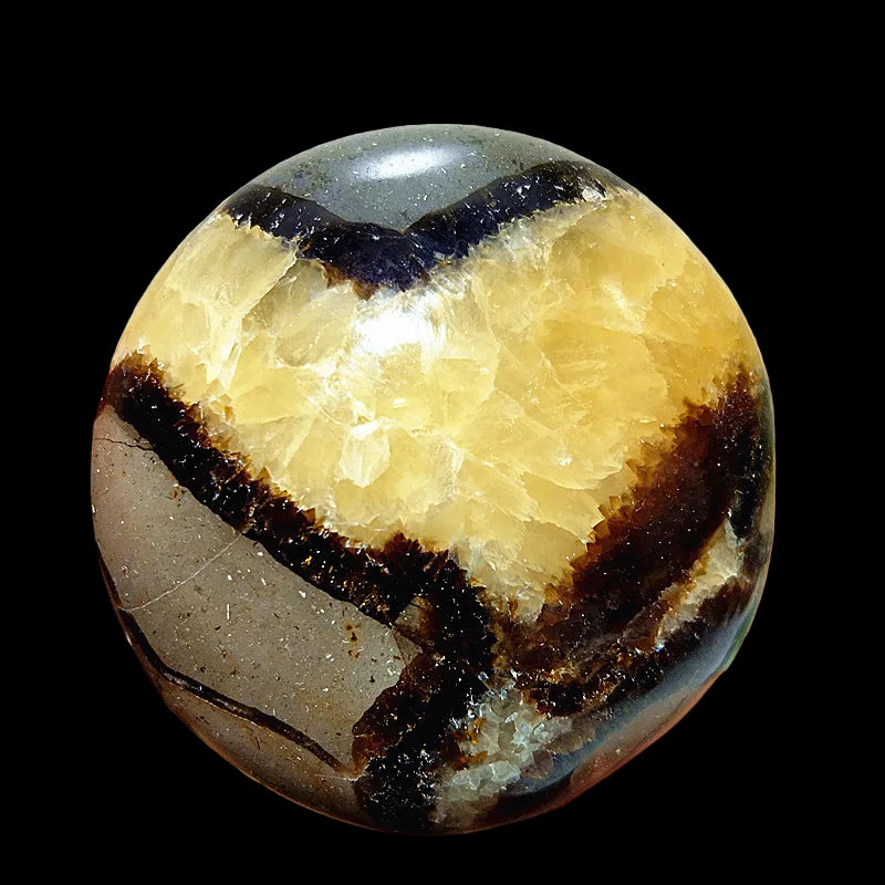 Close-up of a multicolored stone held in a hand with a blurred background