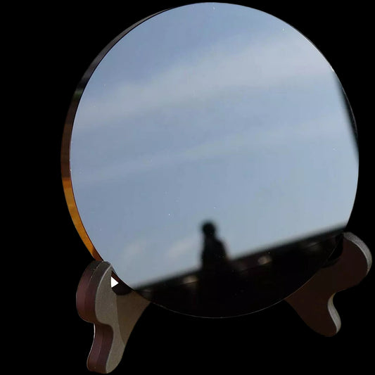 Round blue mirror on a wooden stand with a white background
