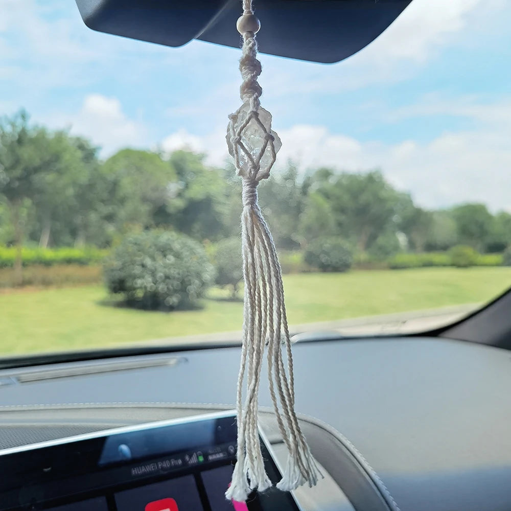 Macrame car hanging with tassel inside a car, view of greenery outside