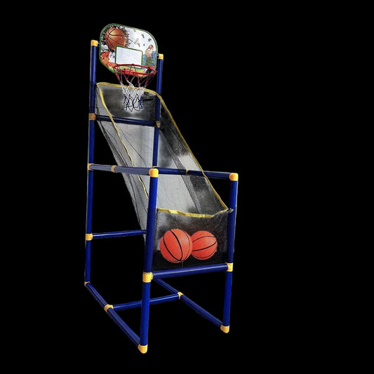 Children's basketball hoop set with two balls on a gray floor against a white wall.