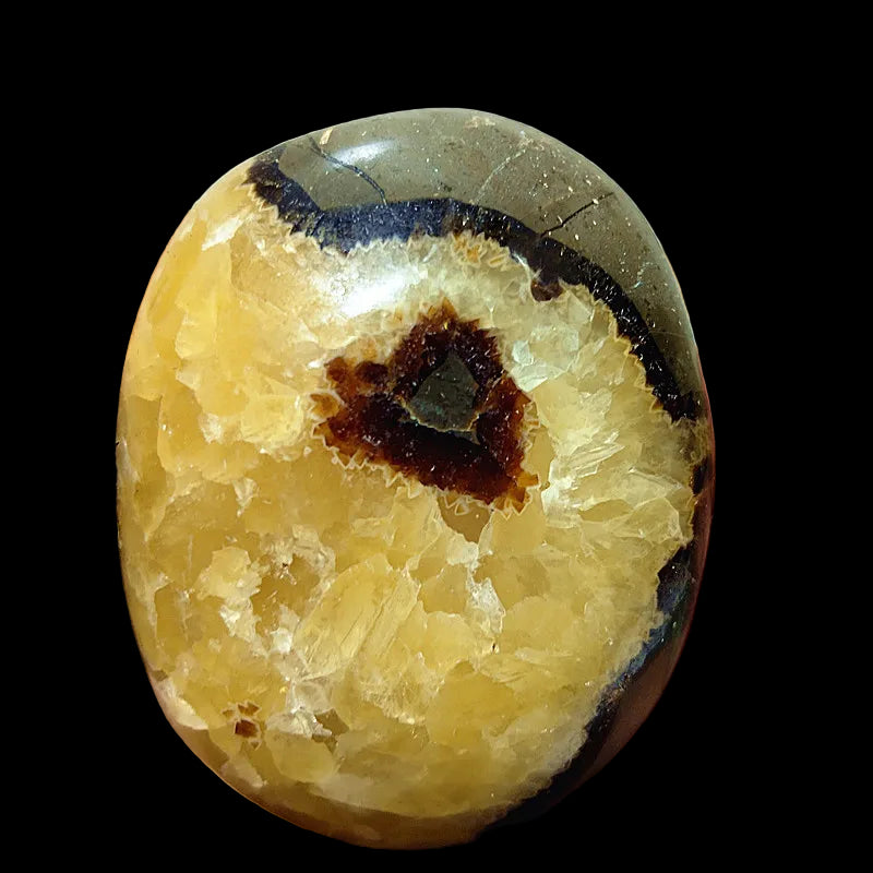 Close-up of a hand holding a semi-precious stone with a unique pattern
