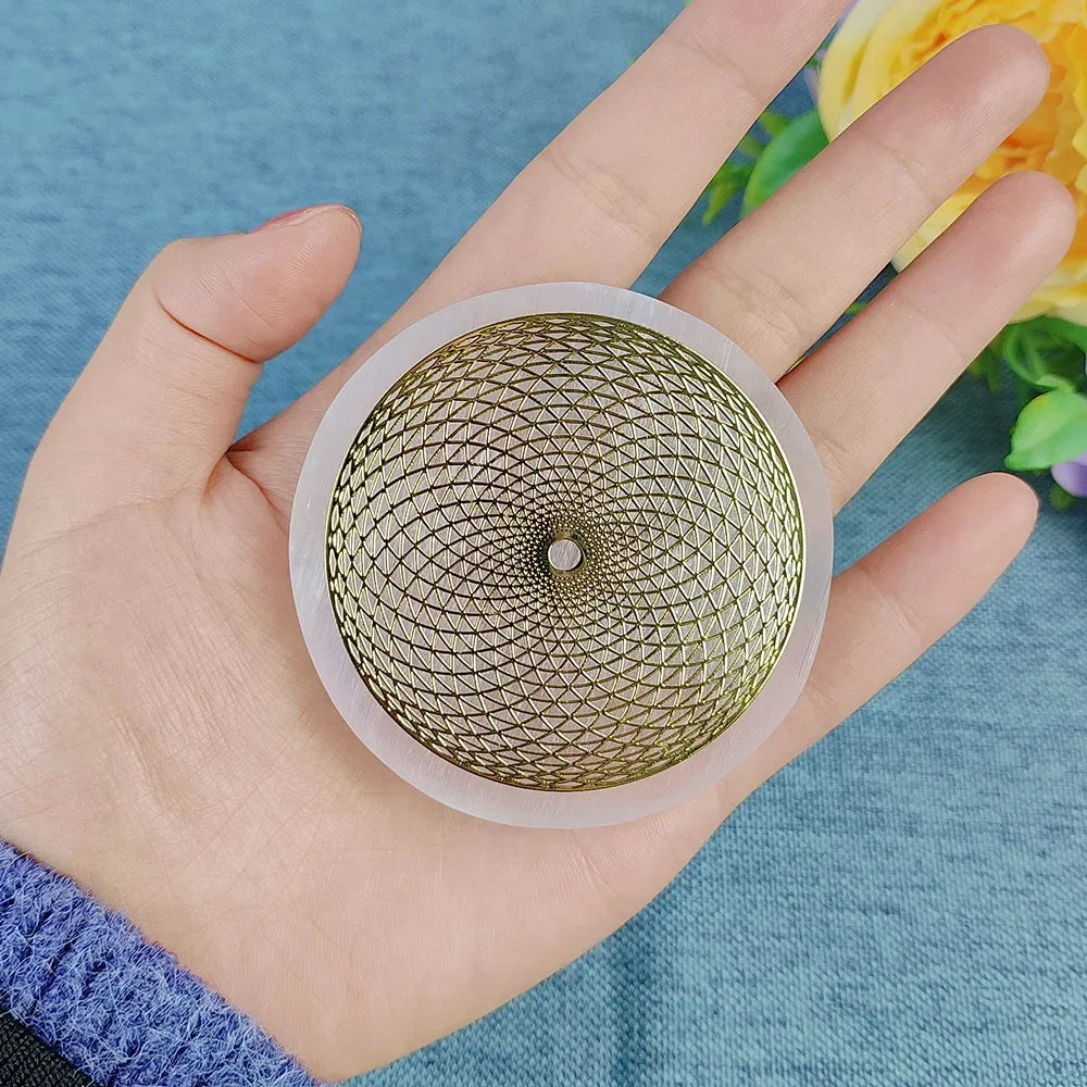 Hand holding a gold and clear decorative object against a blue background