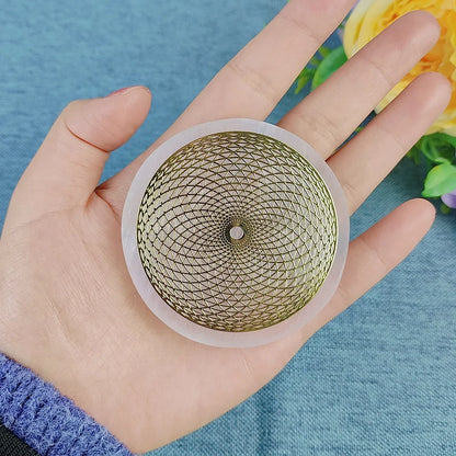 Hand holding a gold and clear decorative object against a blue background