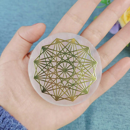 Hand holding a geometric design coaster with a blue background
