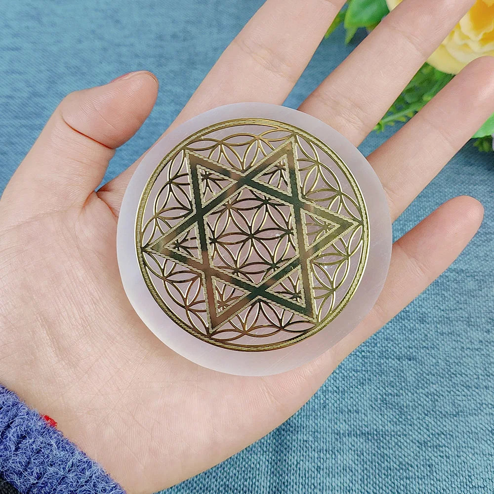 Hand holding a circular object with geometric design on a blue background