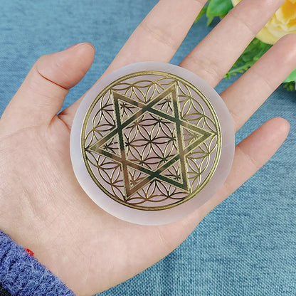 Hand holding a circular object with geometric design on a blue background