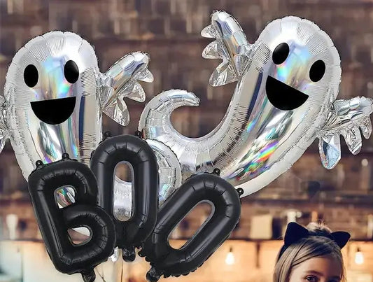 Halloween-themed balloons with 'BOO' and ghost shapes, a child with a carved pumpkin, and a candle in a kitchen.