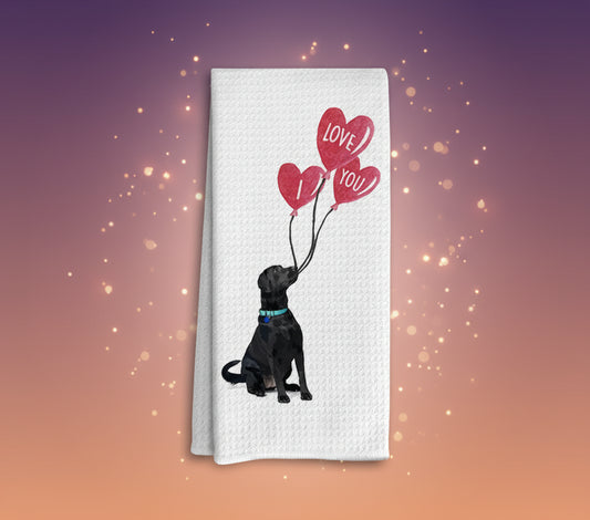 White towel with a black dog holding heart-shaped balloons with 'I Love You' text on a white background