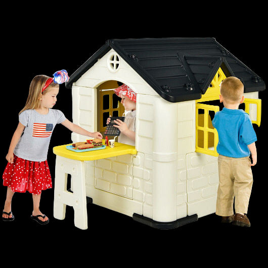 Children playing around a plastic playhouse with a yellow table.