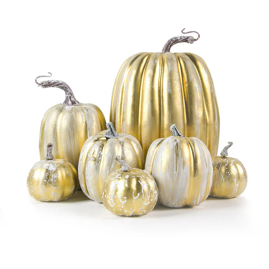Decorative pumpkins in gold and silver on a white background