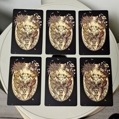 Set of six tarot cards with intricate designs on a white surface